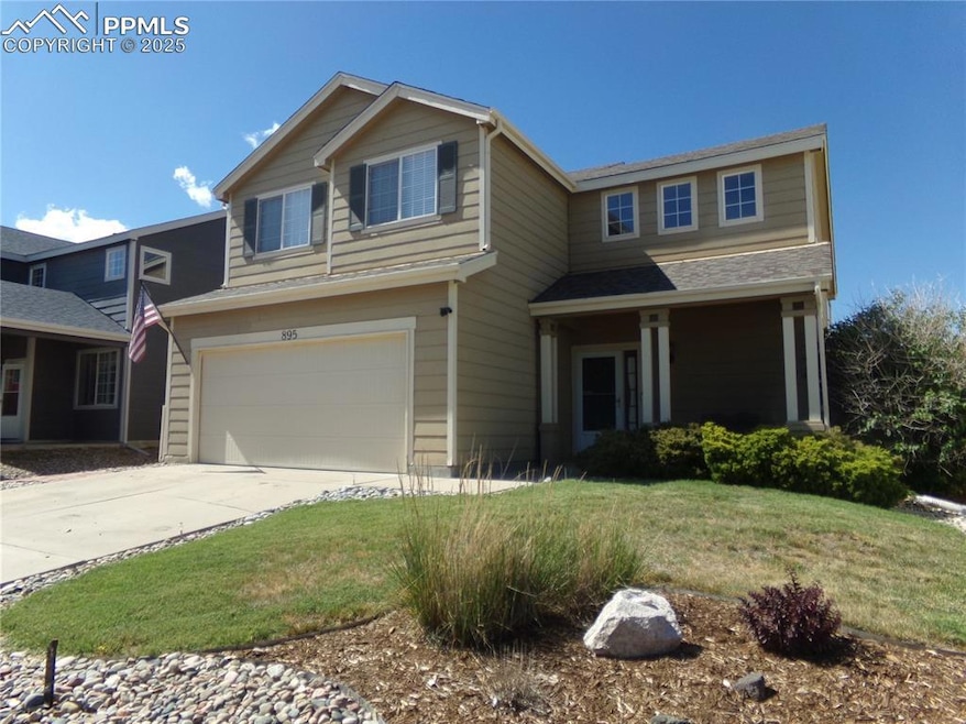 View of front of home with a garage, concrete driveway, and a front yard