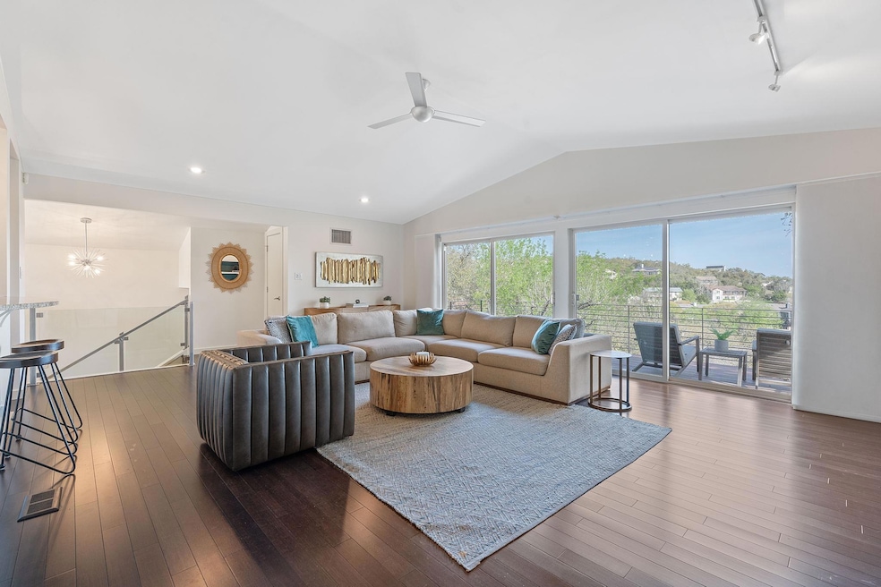 Living room with ceiling fan with notable chandel