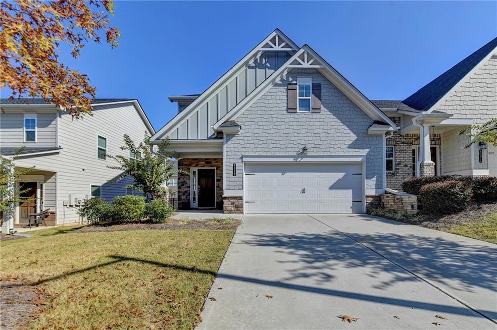 Craftsman house with stone siding, driveway, a fro