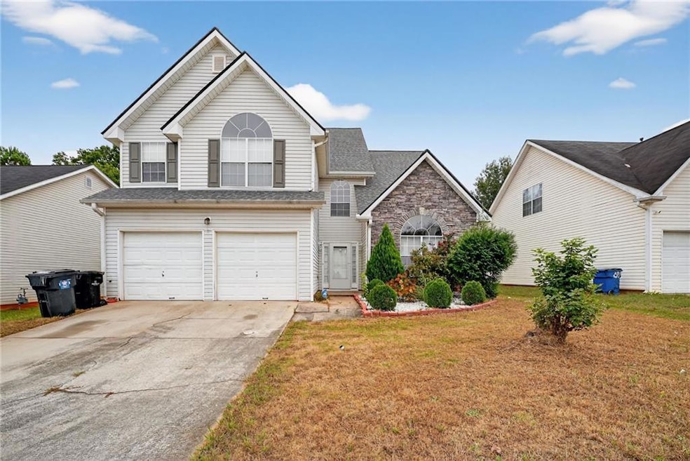 Traditional-style house featuring driveway, an attached garage, a front lawn, and a shingled roof