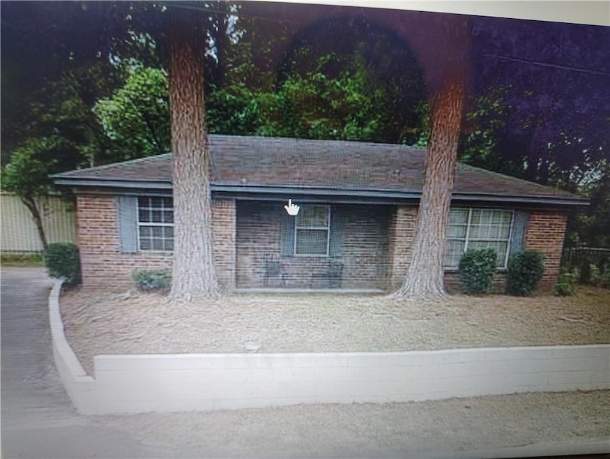 View of front facade featuring brick siding and roof with shingles