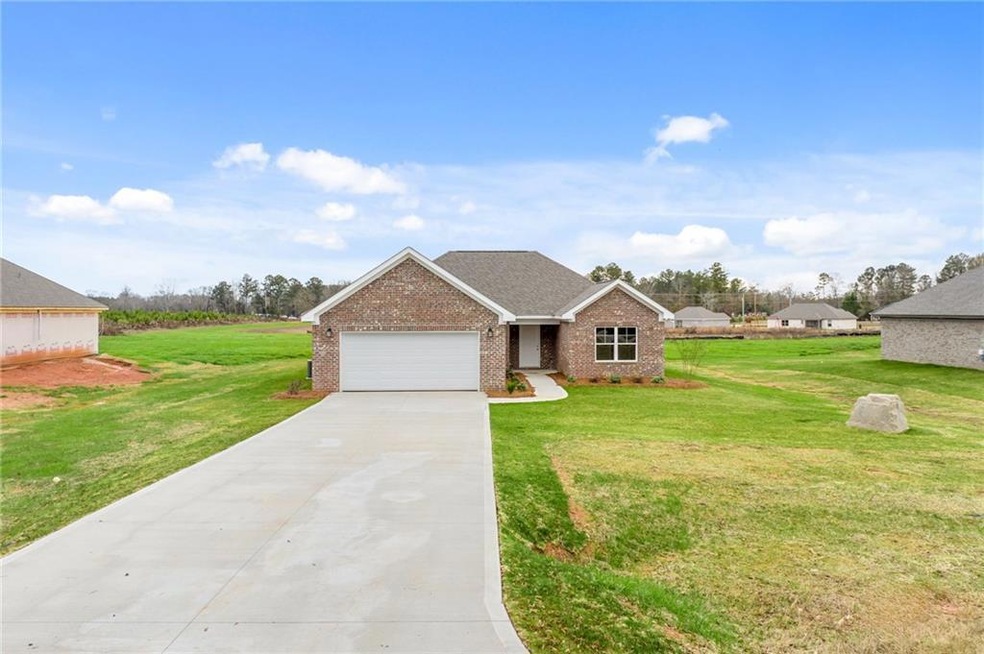 Ranch-style house featuring a garage and a front yard