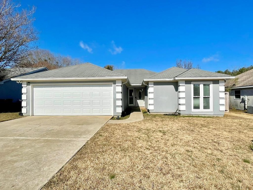 Single story home featuring a front yard and a gar