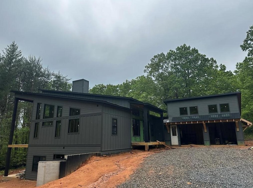 View of side of home with a chimney, driveway, and board and batten siding
