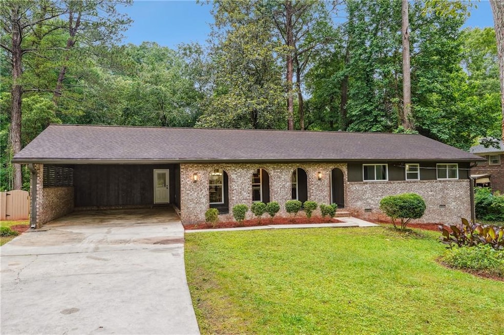 Ranch-style house with concrete driveway, a front lawn, brick siding, and a shingled roof