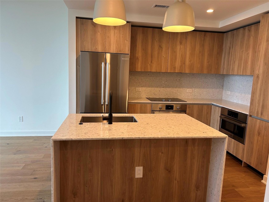 Kitchen with brown cabinetry, visible vents, mode