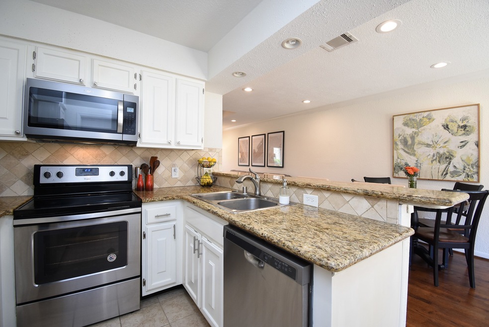 Kitchen offers granite counters and stainless stee