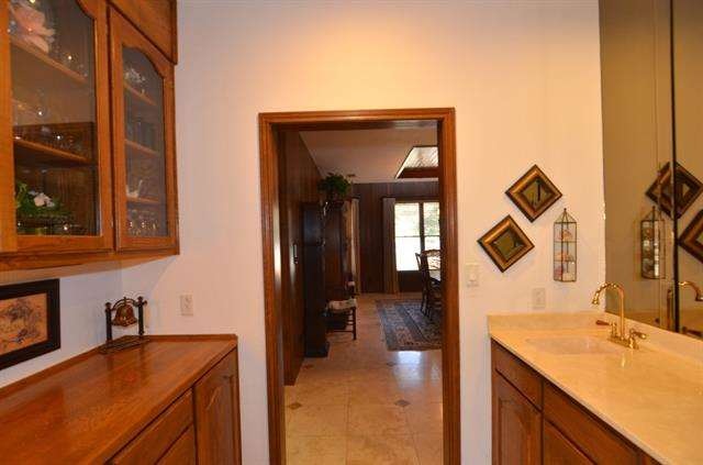 Partial view of wet bar with sink, ice machine and butler pantry.