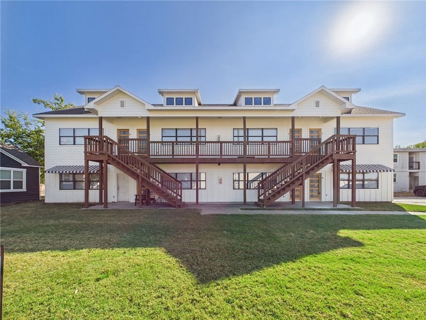 Back of property featuring stairs, a lawn, and a patio area