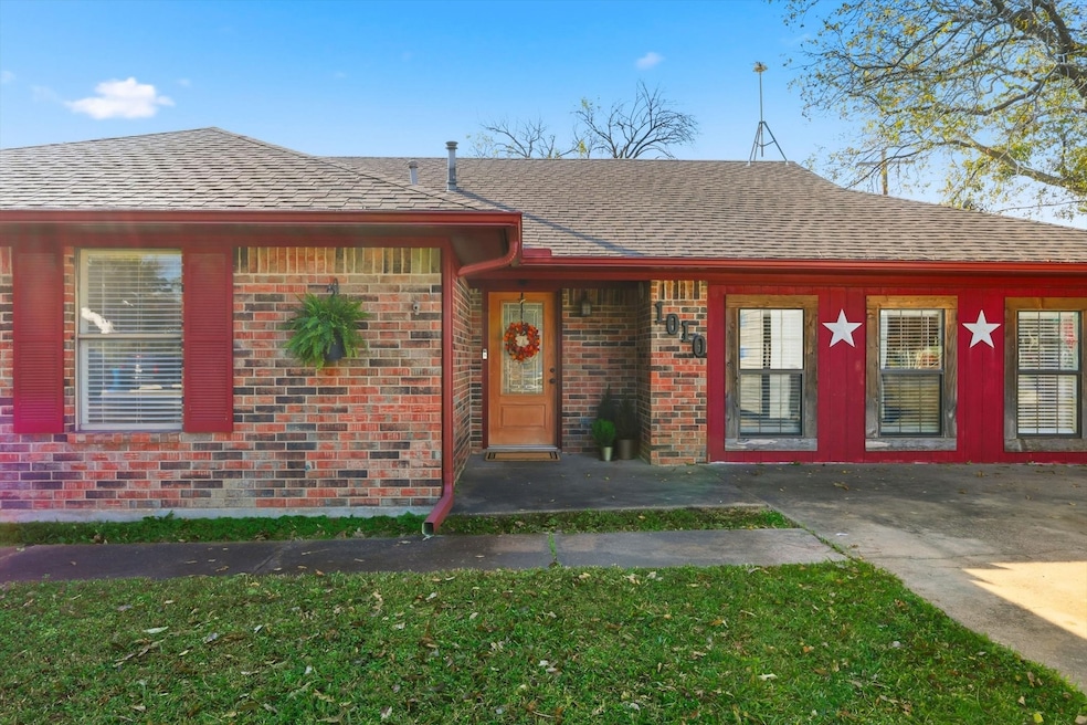 View of front facade with a shingled roof, brick siding, and a front lawn