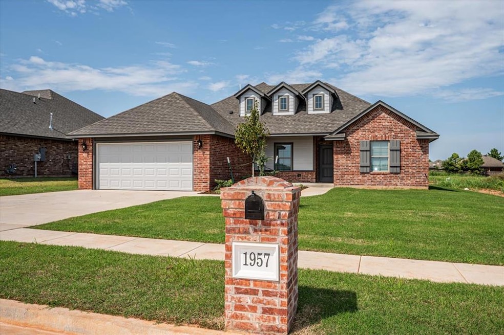 View of front of house featuring a porch, a front lawn, driveway, and brick siding