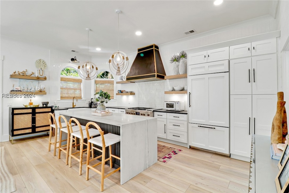 Kitchen featuring white cabinets, a center island,