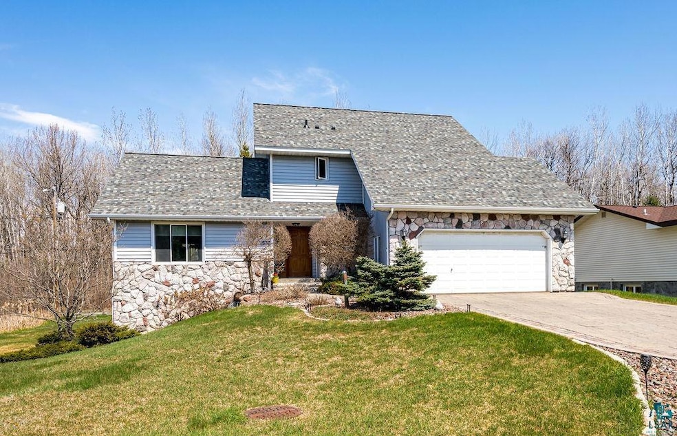 View of front of house featuring stone siding, a g