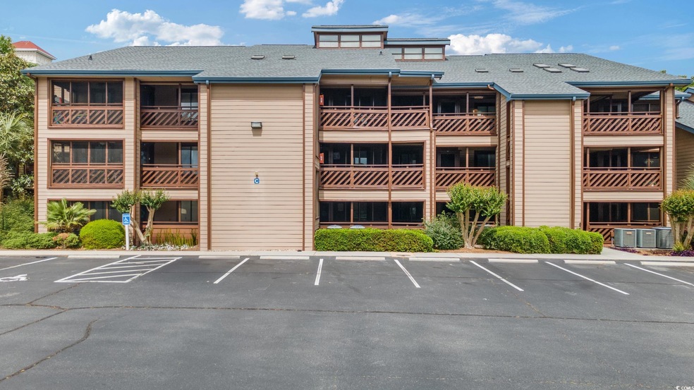 View of property featuring central AC unit and uncovered parking