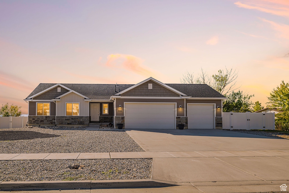 View of front of property with a gate, stone siding, driveway, and a garage