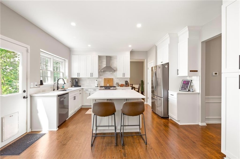 Kitchen with white cabinets, a kitchen island, app