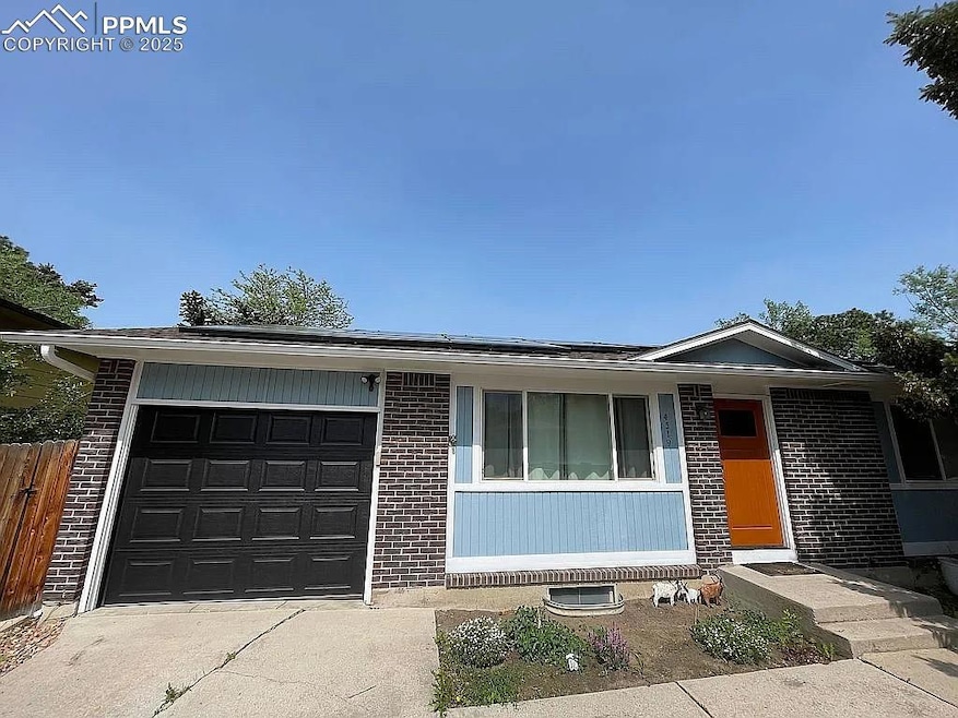 Ranch-style house with brick siding, a garage, and roof mounted solar panels