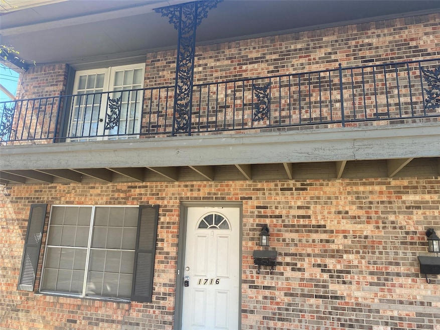 View of exterior entry featuring a balcony and bri