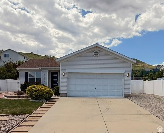 Single story home with driveway and a garage