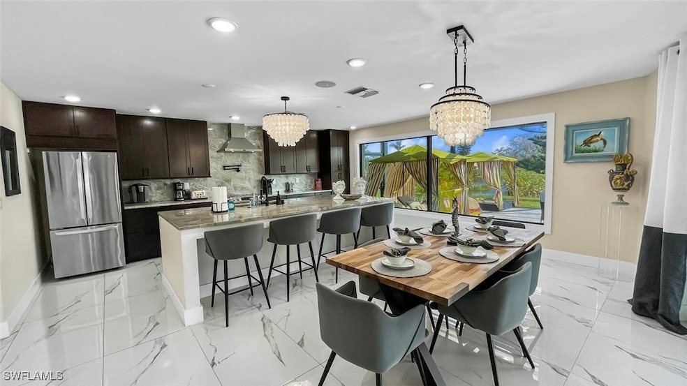 Dining room featuring a chandelier, light marble finish floors, and recessed lighting