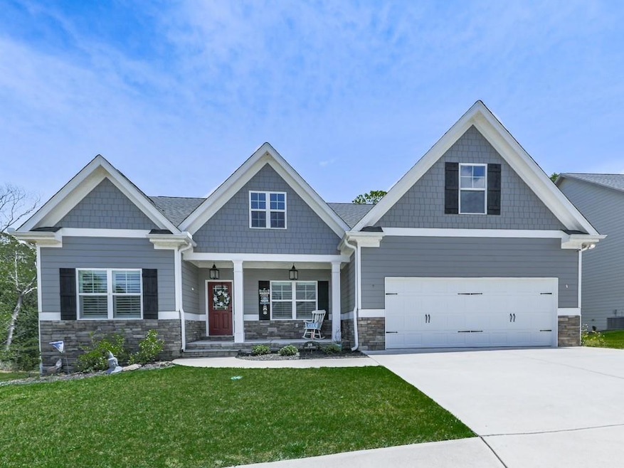 Craftsman-style home featuring stone siding, a por