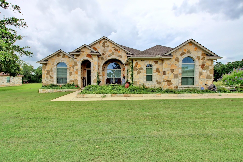 View of front facade with stone siding, a front y