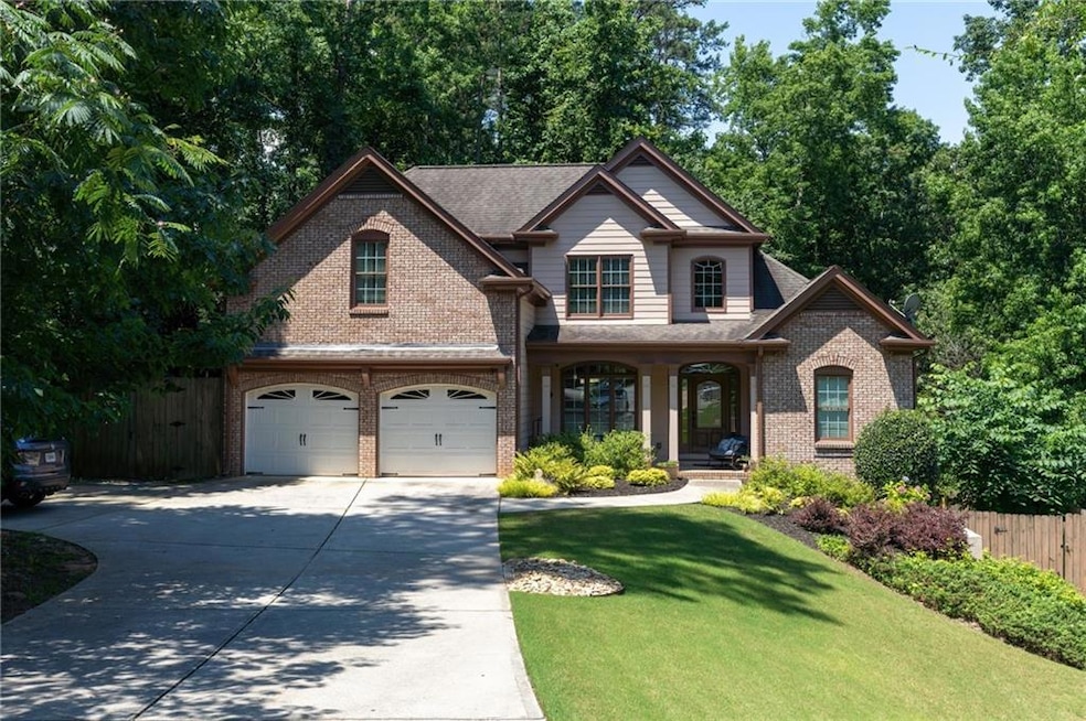 View of front facade featuring brick siding, driveway, covered porch, and an attached garage