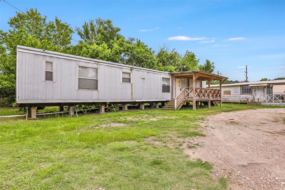 This photo features a mobile home with a wooden po