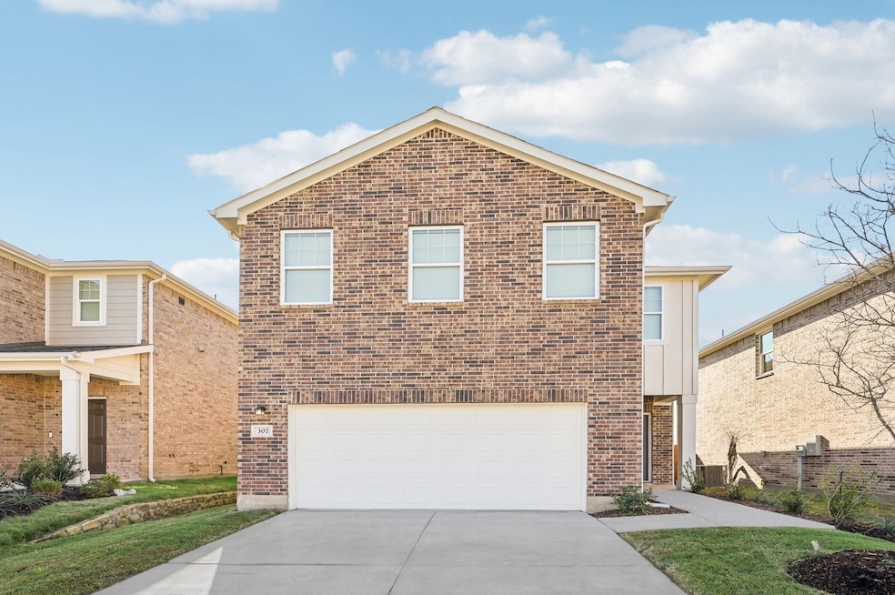 Traditional-style home with driveway, a garage, brick siding, and board and batten siding