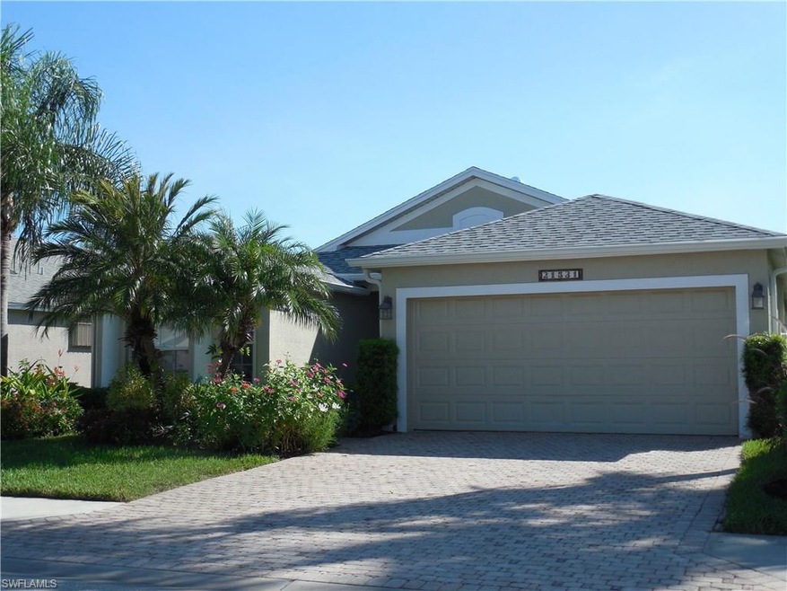 Front View with paver driveway and lush landscapin