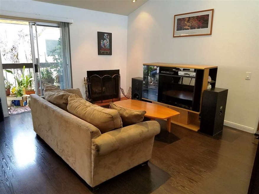 Vaulted ceiling and wood-burning fireplace in livi