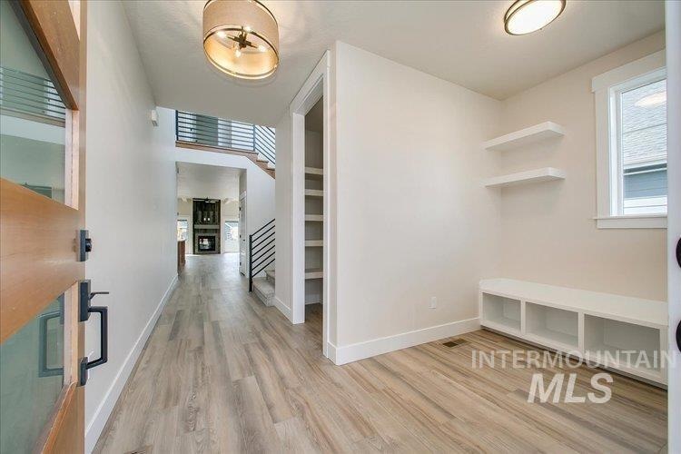 Mudroom featuring light wood-type flooring and baseboards