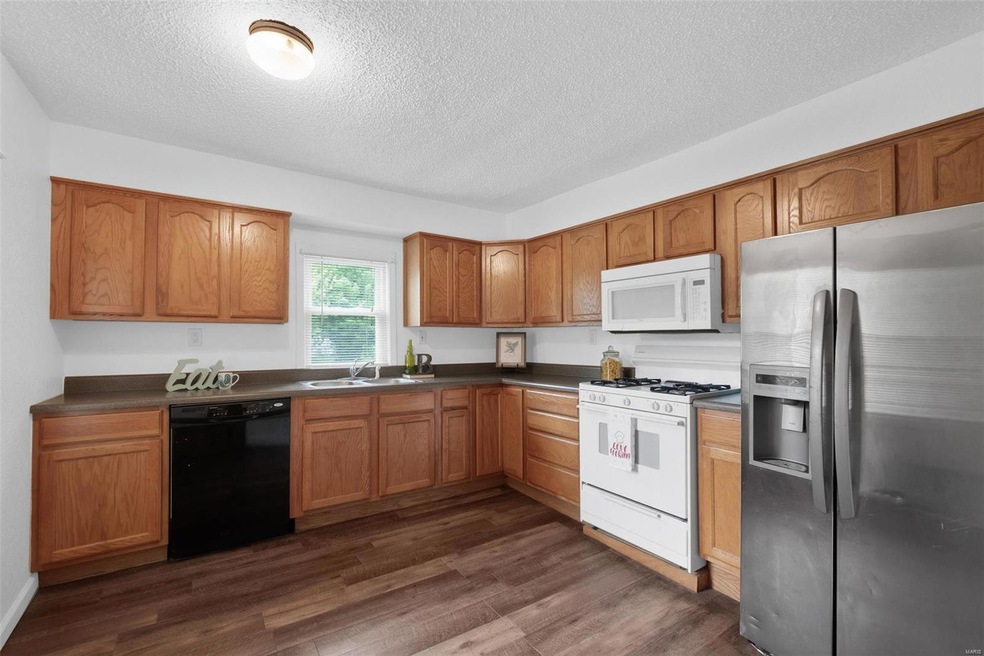 Updated Kitchen with plenty of oak cabinetry, dishwasher, refrigerator, gas range and microwave.