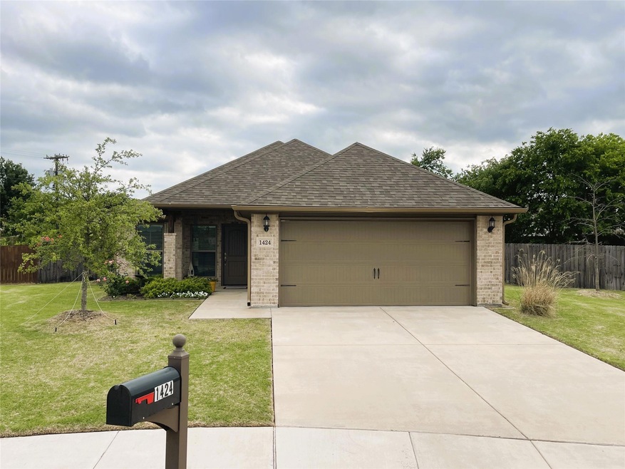 View of front of house featuring a garage and front lawn