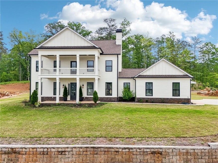 Greek revival house with a balcony, a front yard, 