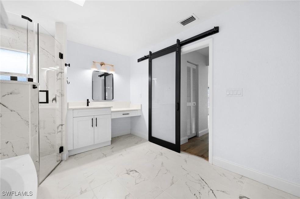 Bathroom with vanity and a shower with door