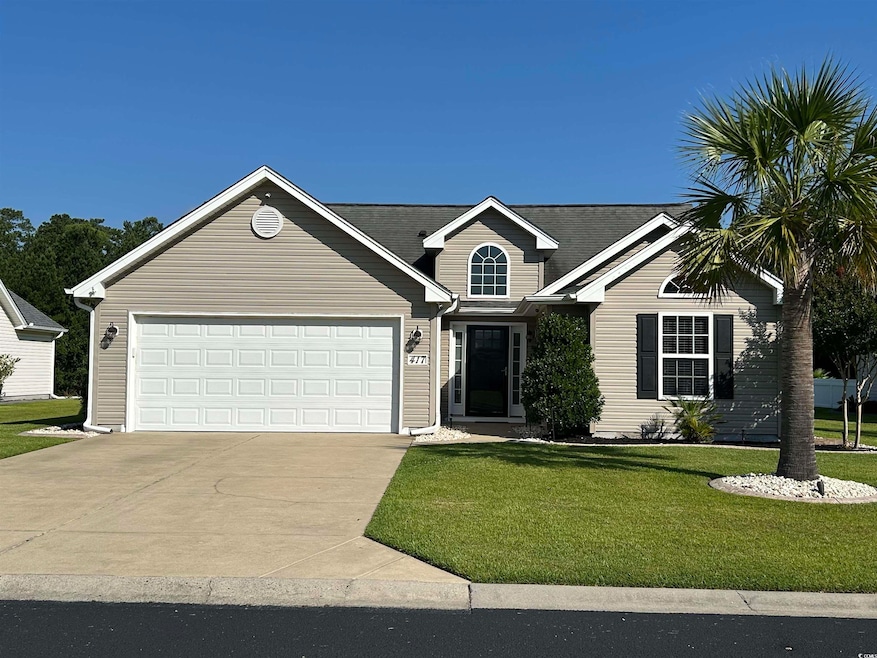 View of front of home featuring concrete driveway, a front lawn, and a garage