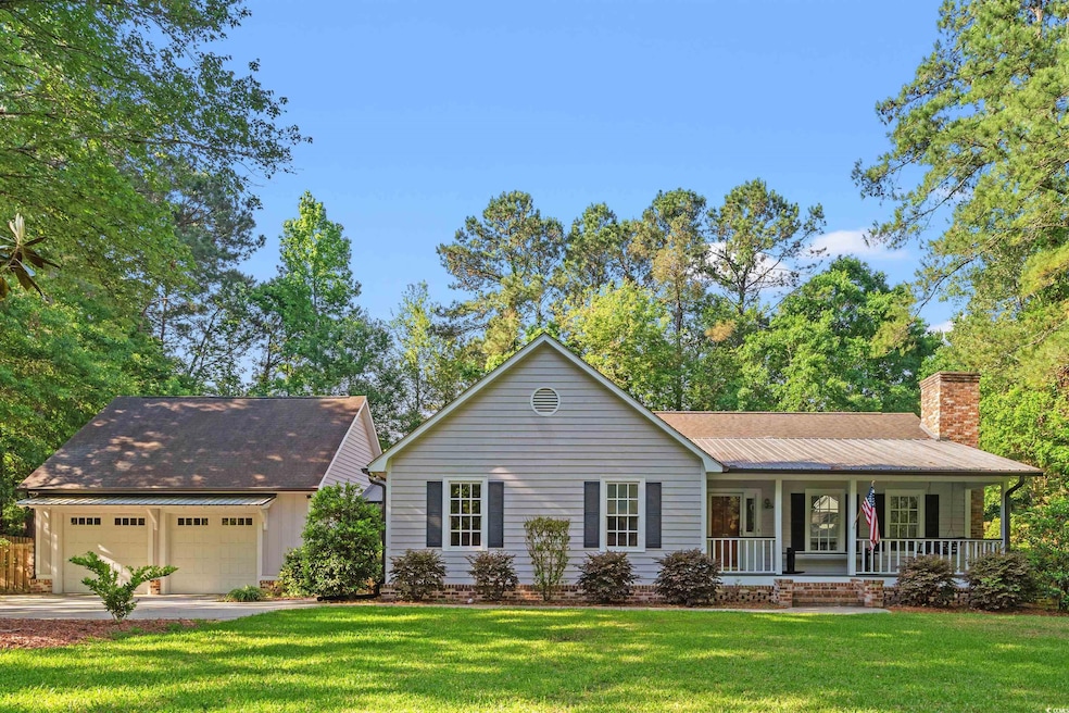 Ranch-style home featuring covered porch, a chimne