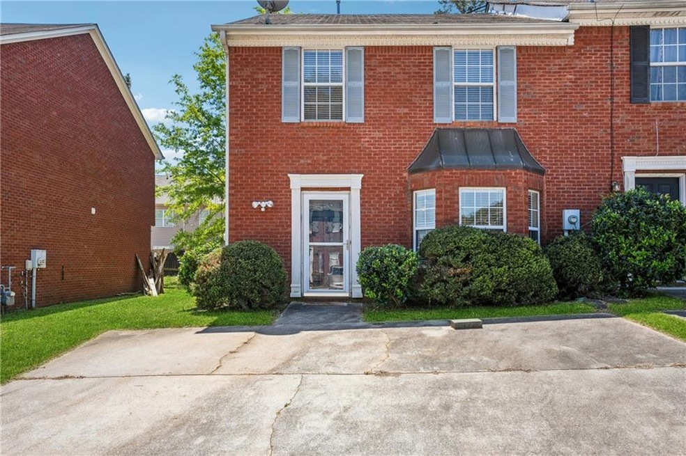 View of property featuring brick siding, a front l