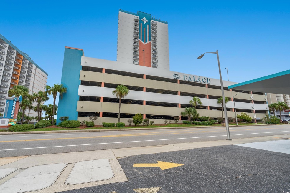 View of apartment building / complex with uncovered parking