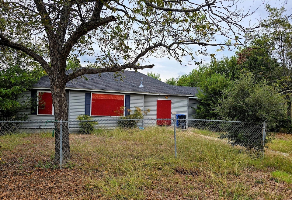 View of front facade with a fenced front yard and roof with shingles