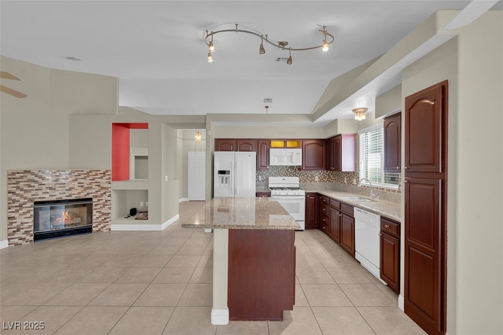 Kitchen with white appliances, a sink, a center is