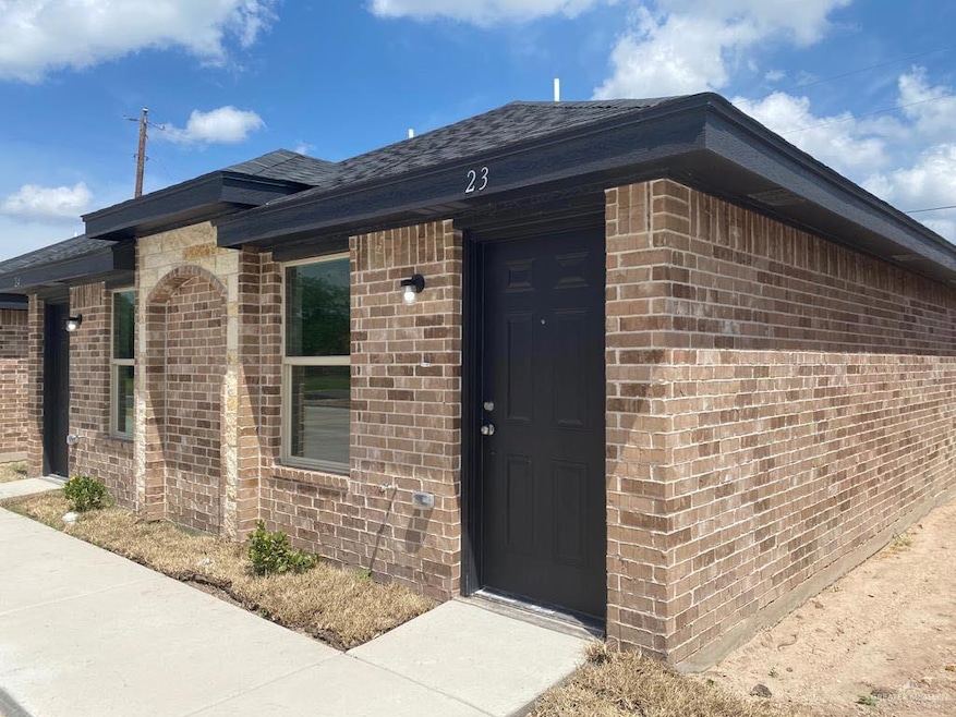 Property entrance featuring brick siding and roof with shingles
