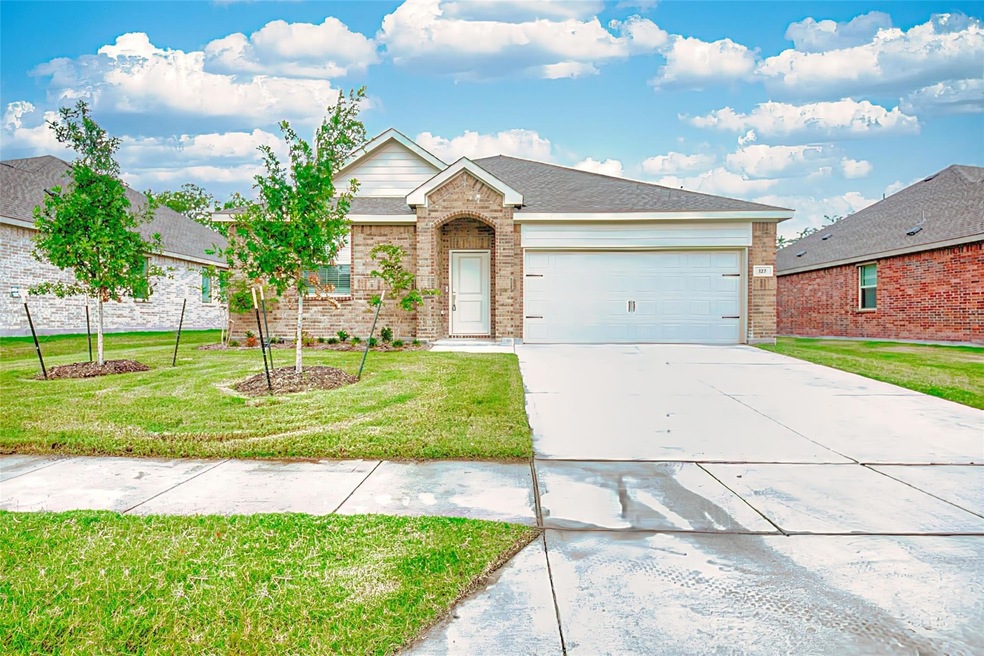 View of front of home with a garage and a front lawn
