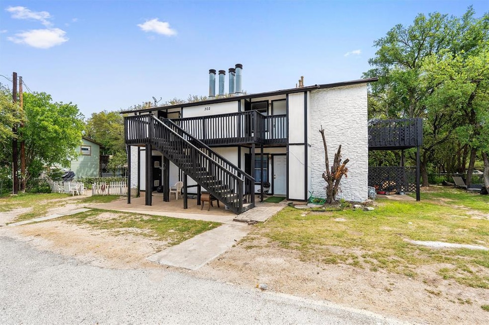 Back of house with stairway, fence, and a wooden 