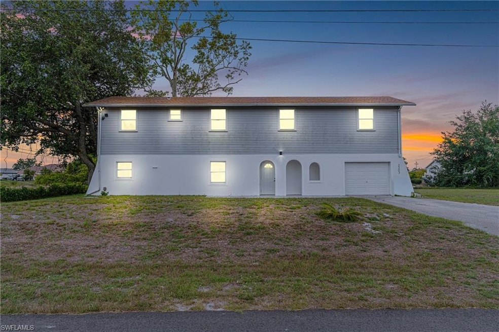 View of front of property featuring driveway, a garage, a lawn, and stucco siding