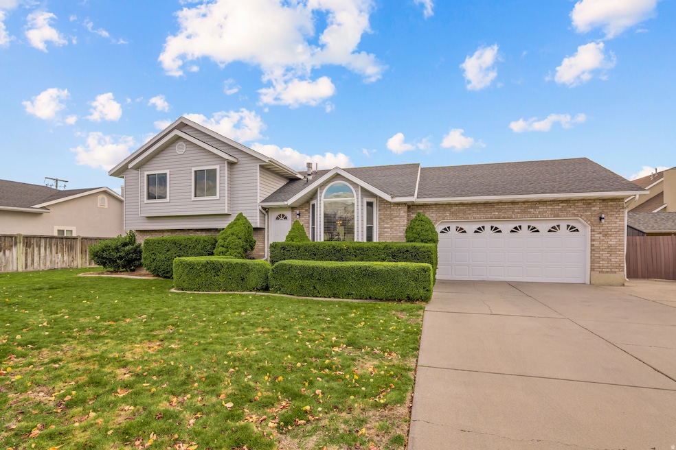 Split level home with brick siding, a shingled roof, concrete driveway, and an attached garage