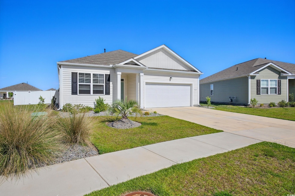 Ranch-style home featuring a garage, concrete driveway, and board and batten siding