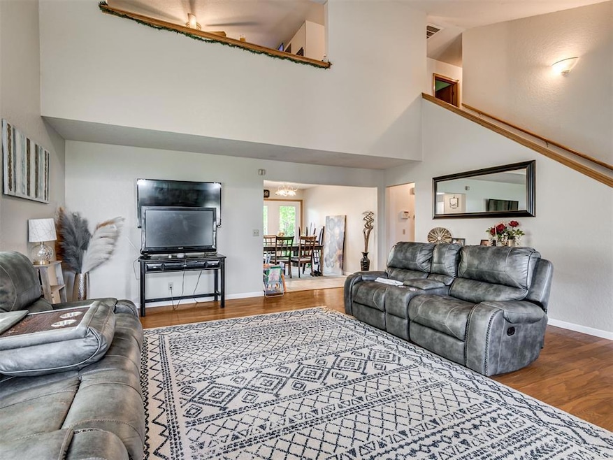 Living room with wood finished floors and high vaulted ceiling