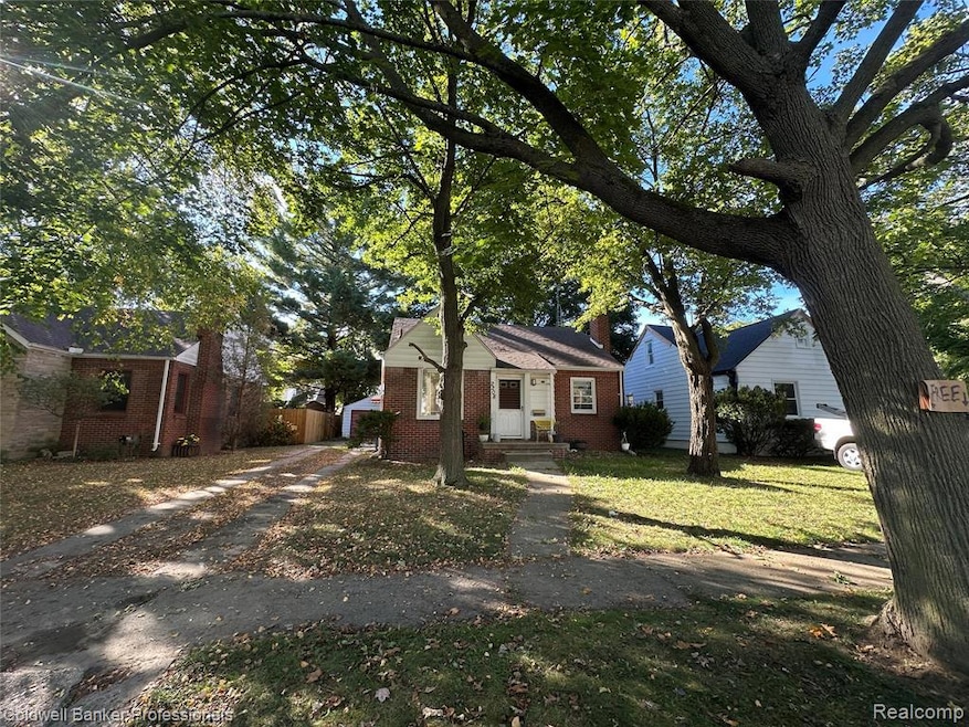 Bungalow-style house with a chimney, a front yard, and brick siding